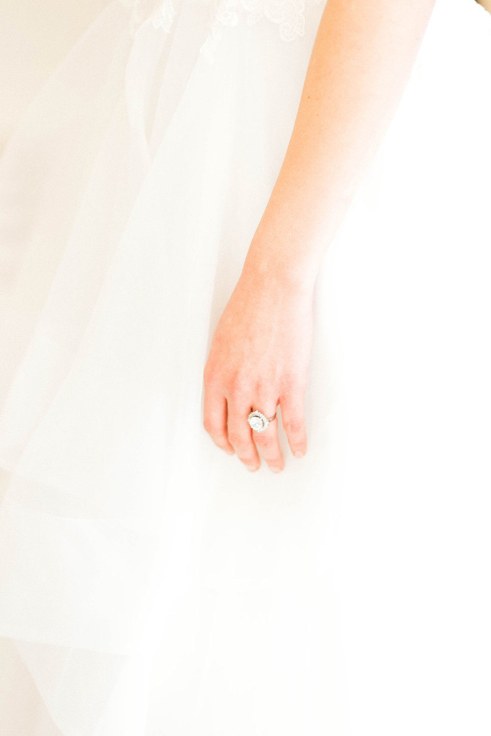An oval engagement ring on a bride's finger