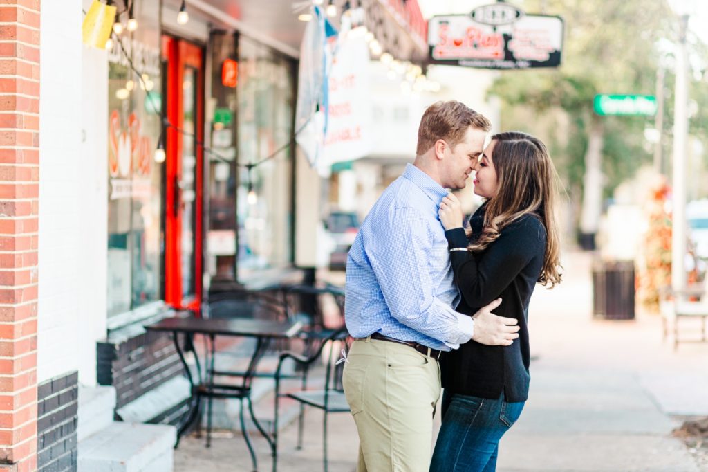A couple kissing in front of a downtown pizza shop in NC