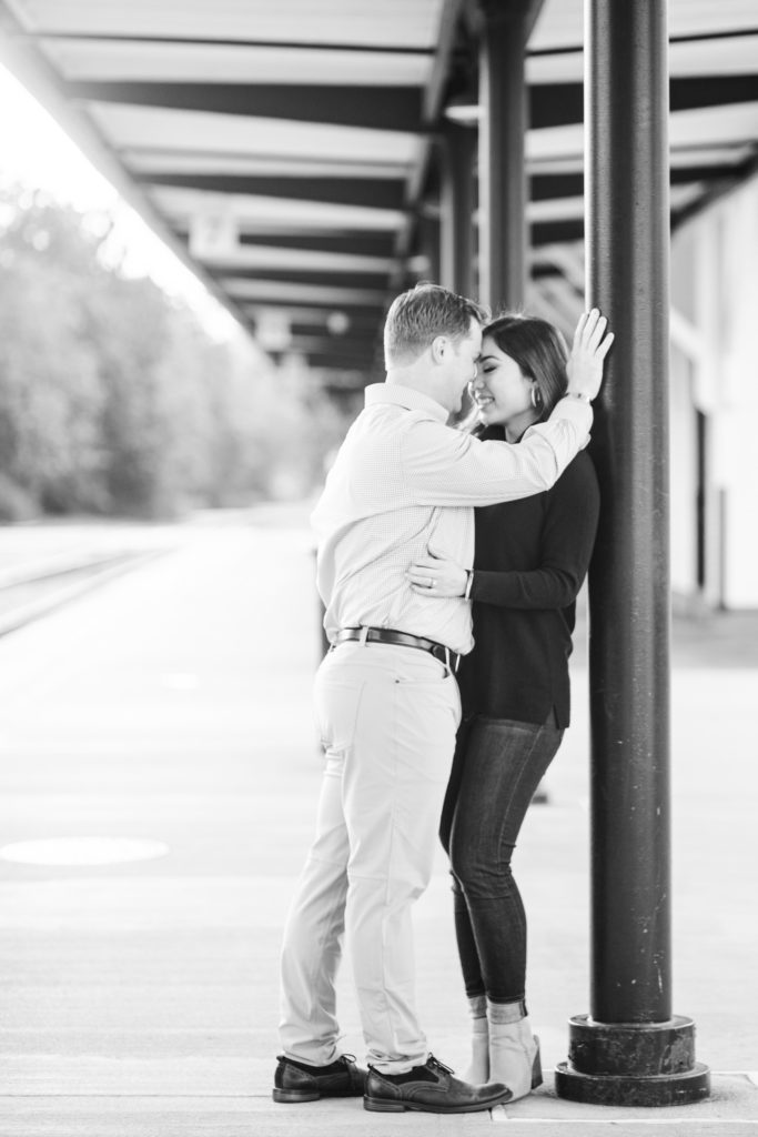 A couple kissing at a downtown train station near Raleigh, NC
