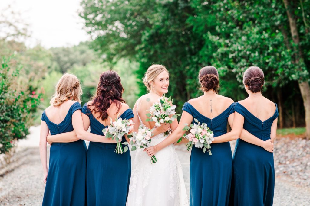Bride and her bridesmaids at a rustic Barn at Woodlake Meadows wedding in Bear Creek, NC| Tierney Riggs Photography
