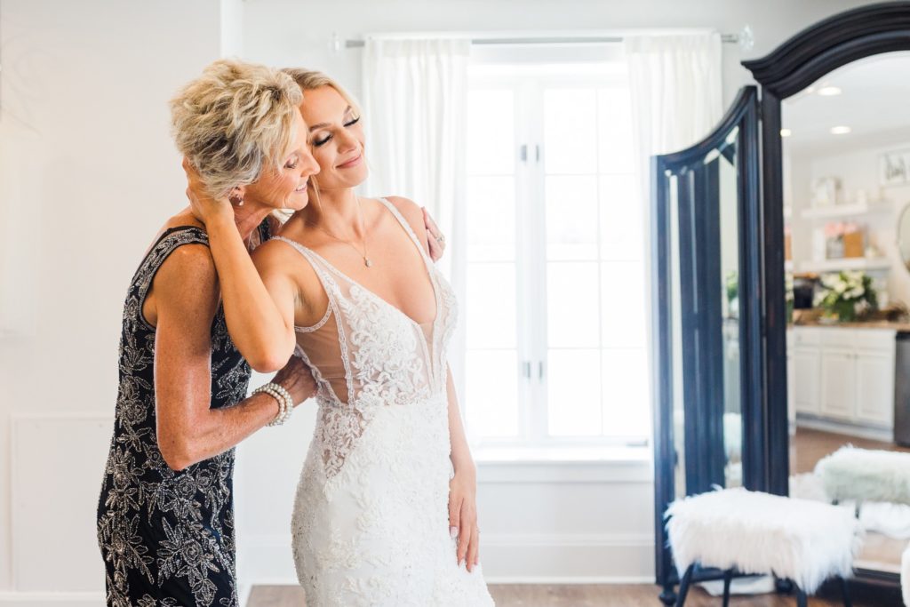 A MOM AND DAUGHTER HUGGING ON HER WEDDING DAY