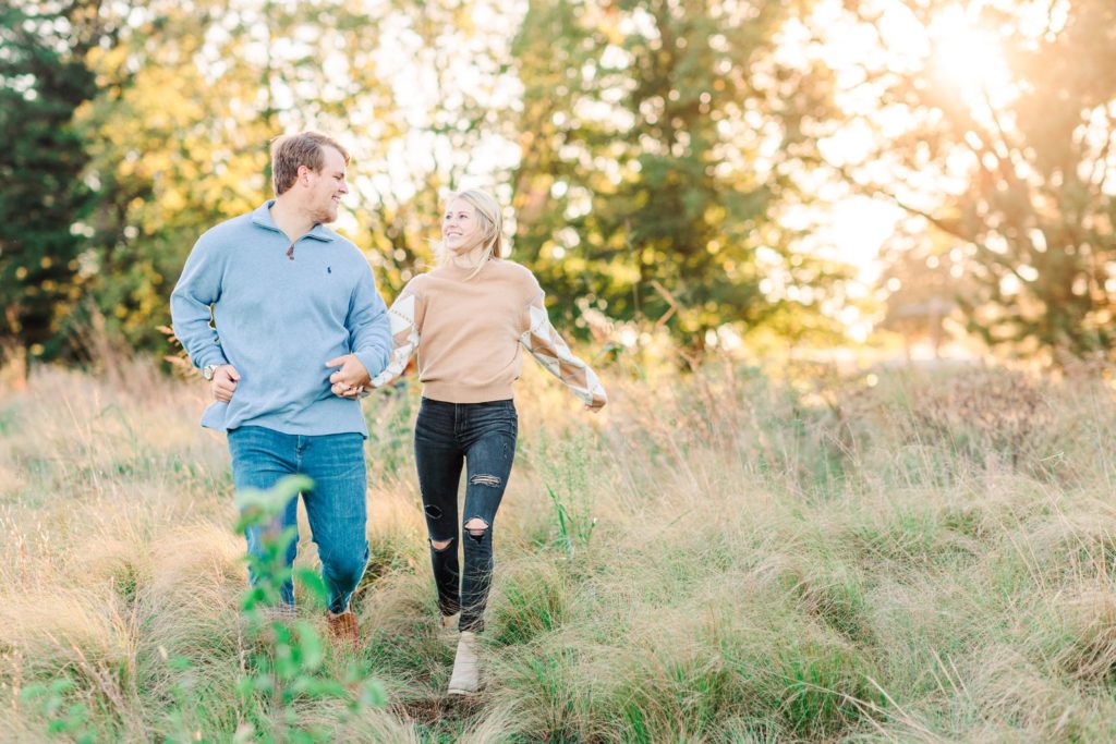 Couple running through a field for their Raleigh engagement photos