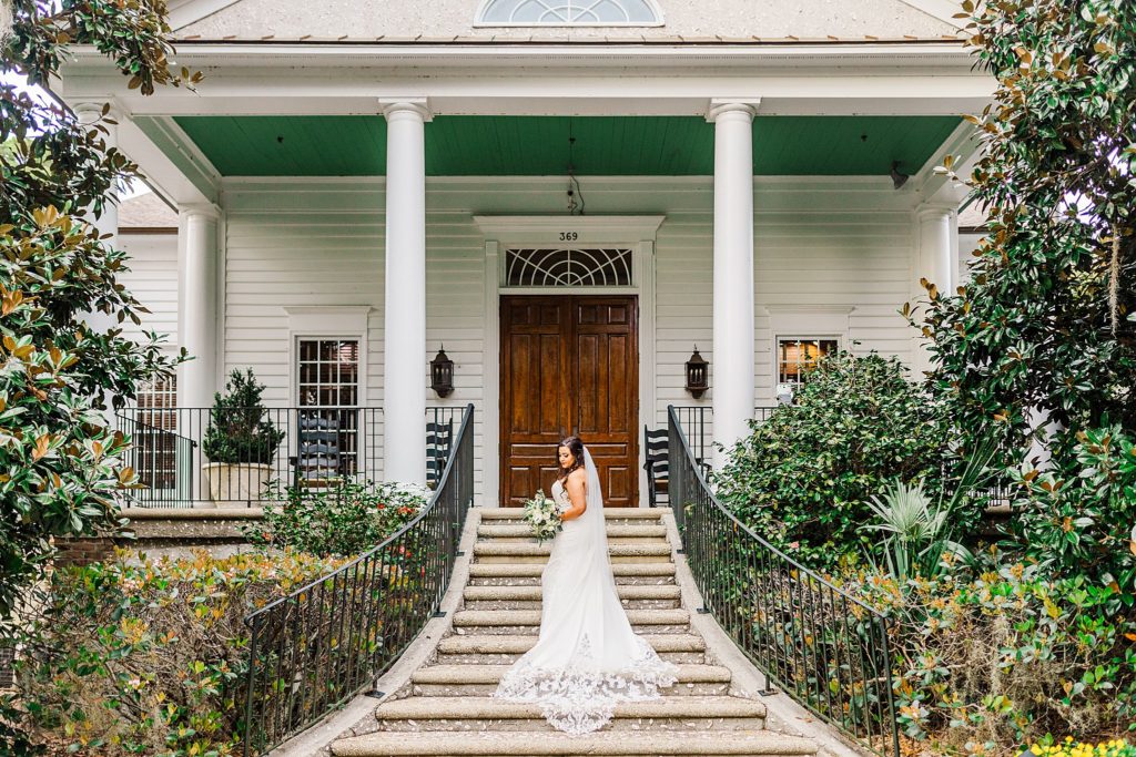 A bride posing in front of a historic building by Charleston wedding photographer Tierney Riggs