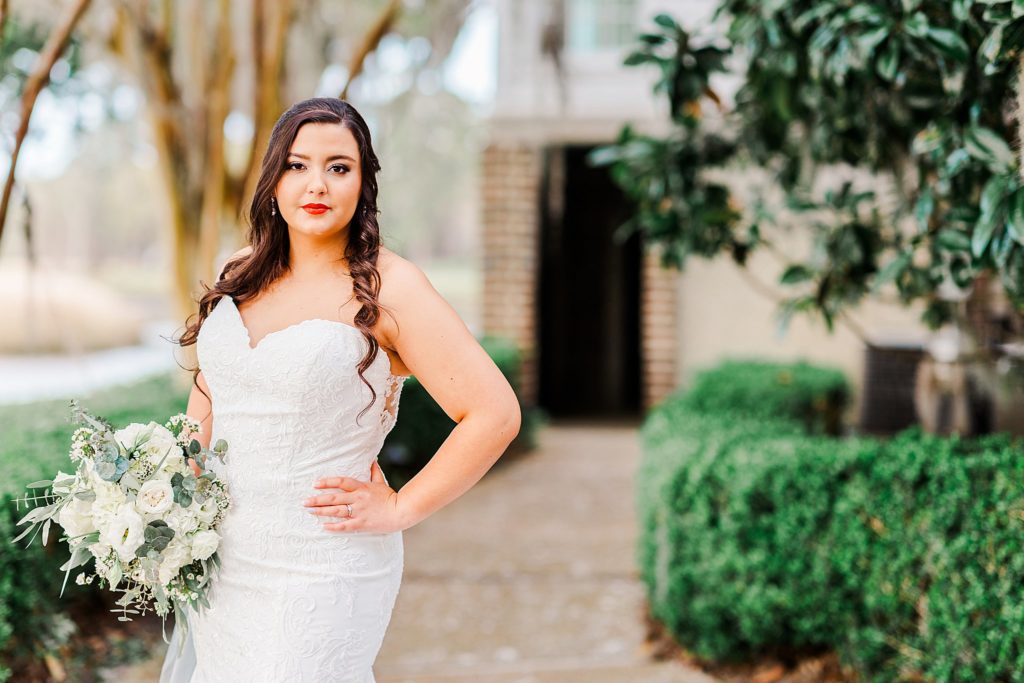 A bride posing in front of a historic building by Charleston wedding photographer Tierney Riggs