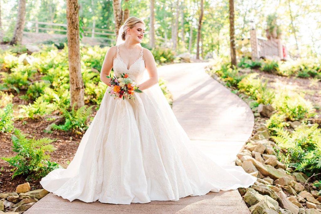 A bride walking down a path at her wedding venue in South Carolina captured by Tierney Riggs Photography 