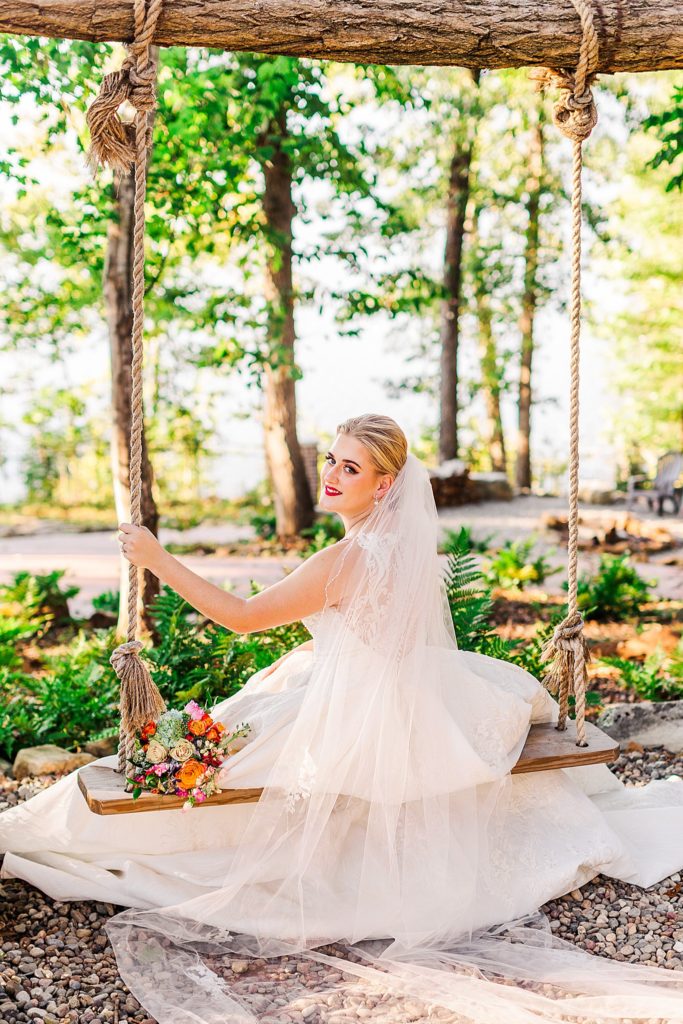 A bride sitting on a swing at her wedding venue