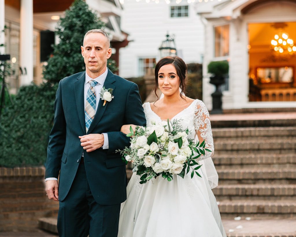 A bride and her dad walking down the aisle for her Highgrove Estate wedding ceremony