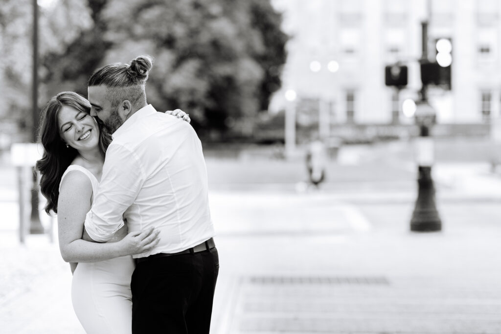 A couple hugging in front of the State Capitol Building in Raleigh, NC