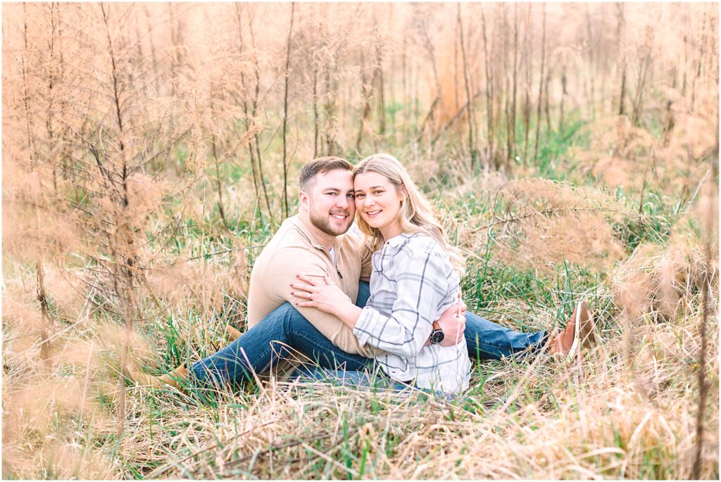 Couple sitting in an enchanted meadow for their engagement photos