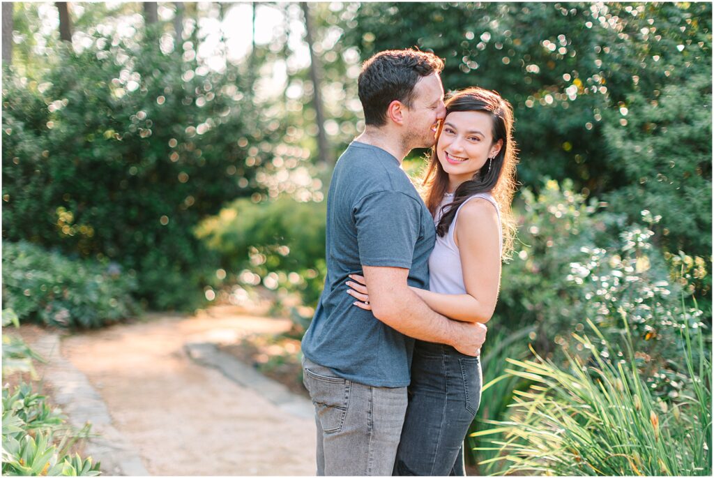 Couple kissing in the lush Raleigh, NC gardens