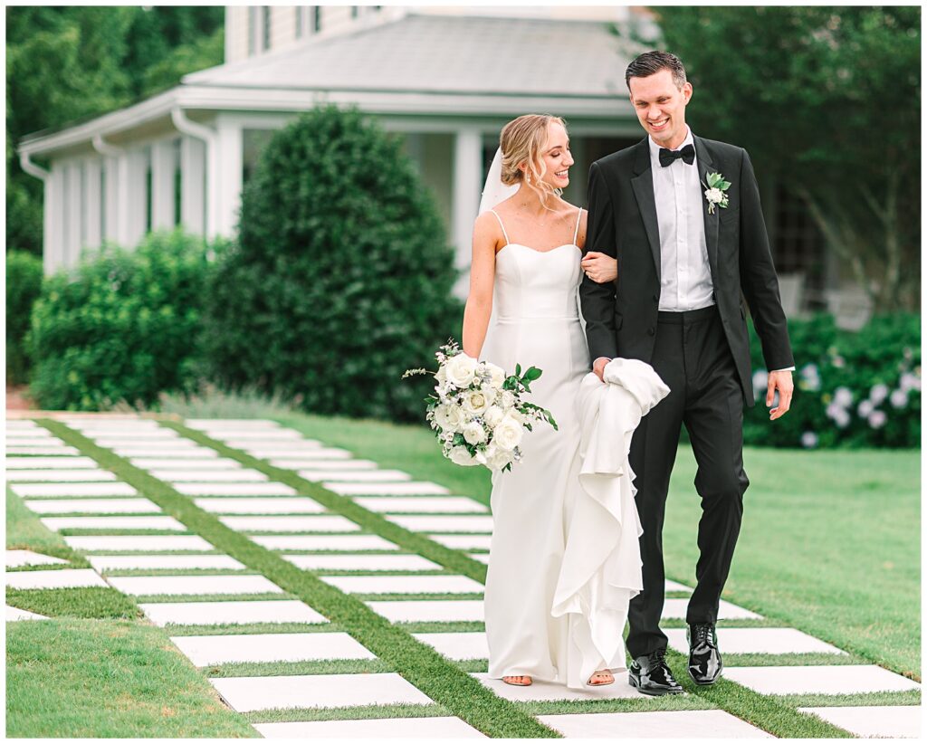 Couple walking in front of Walnut Hill wedding venue in Raleigh, NC