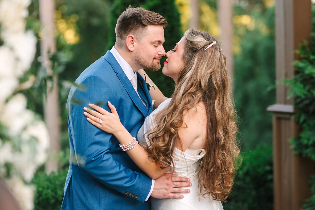 Couple snuggling under the pergola at Highgrove Estate in Fuquay-Varina, NC