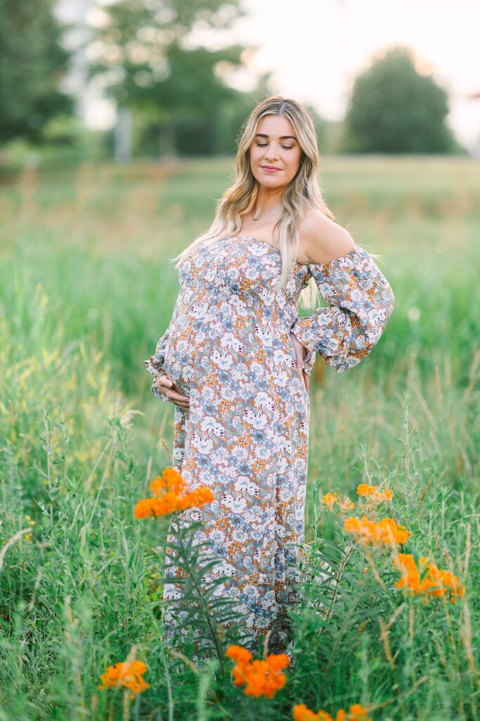 A photo of a mom in a field taken by Raleigh Maternity Photographer, Tierney Riggs