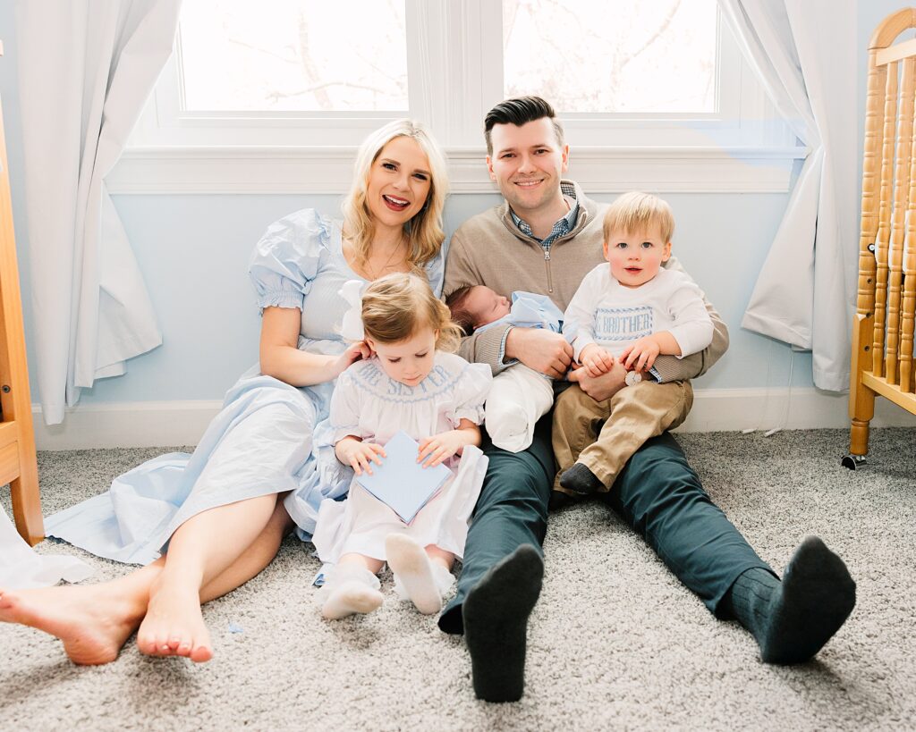 A family in the baby's nursery during their newborn photo session in Apex